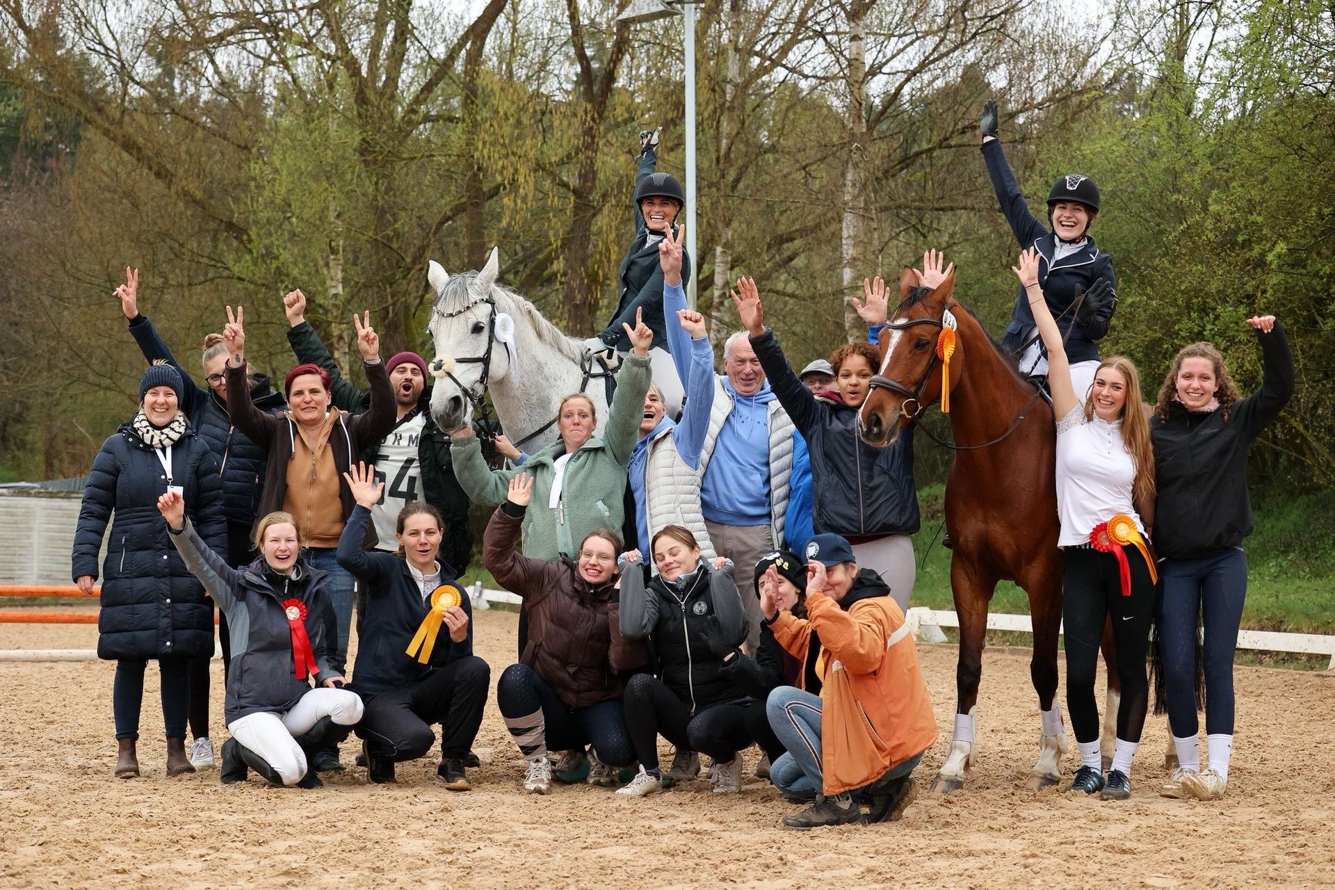 Jubelnde Mitglieder mit Pferden und Schleifen nach dem Reiterfest